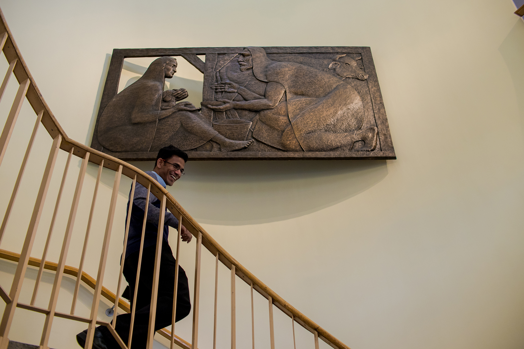 Student walking down the stairs past the Holy Family Sculpture in the Thomas Carr Centre