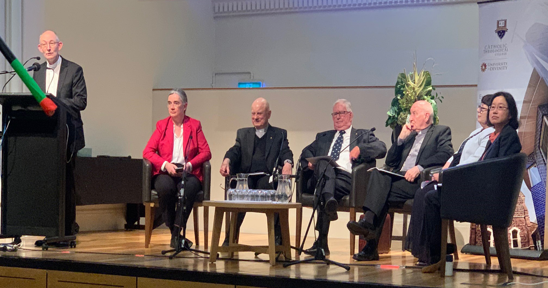 Very Rev. Kevin Lenehan speaking at the 2022 Knox Public Lecture; Seated left to right: Dr Catherine Playoust, Ref. Prof. Austin Cooper OMI AM; Ref. Prof. Francis J. Moloney SDB; Bishop Terence Curtin; Dr Rosemary Canavan, and Sr Michelle Goh RSM