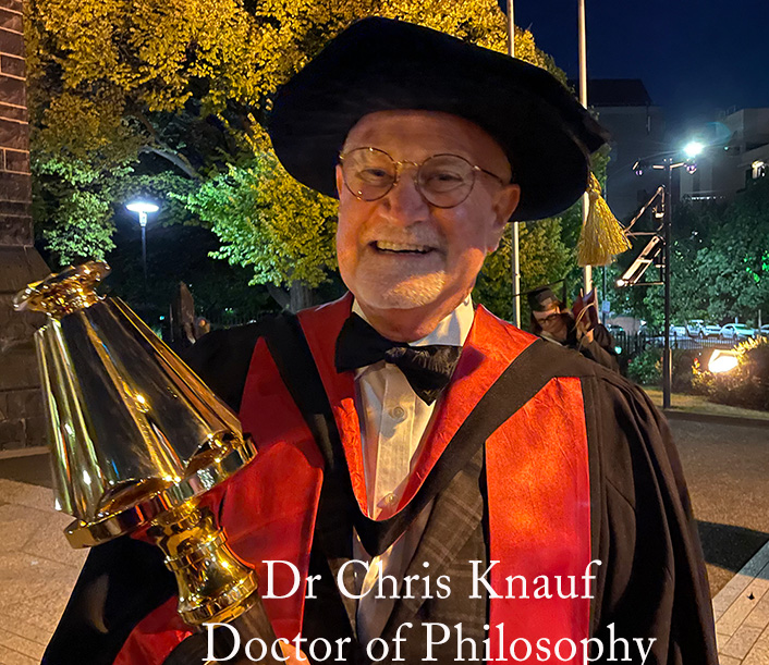Dr Chris Knauf holding the mace at the 2023 University of Divinity graduation