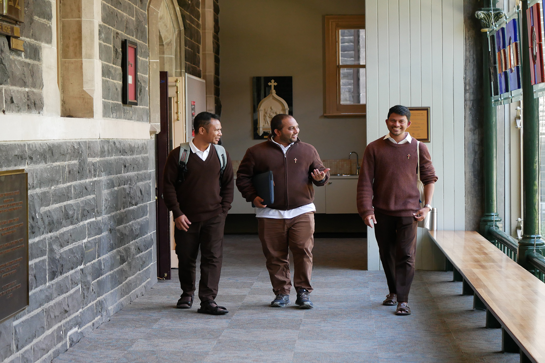 Three MGL seminarians walking past the stations of the cross